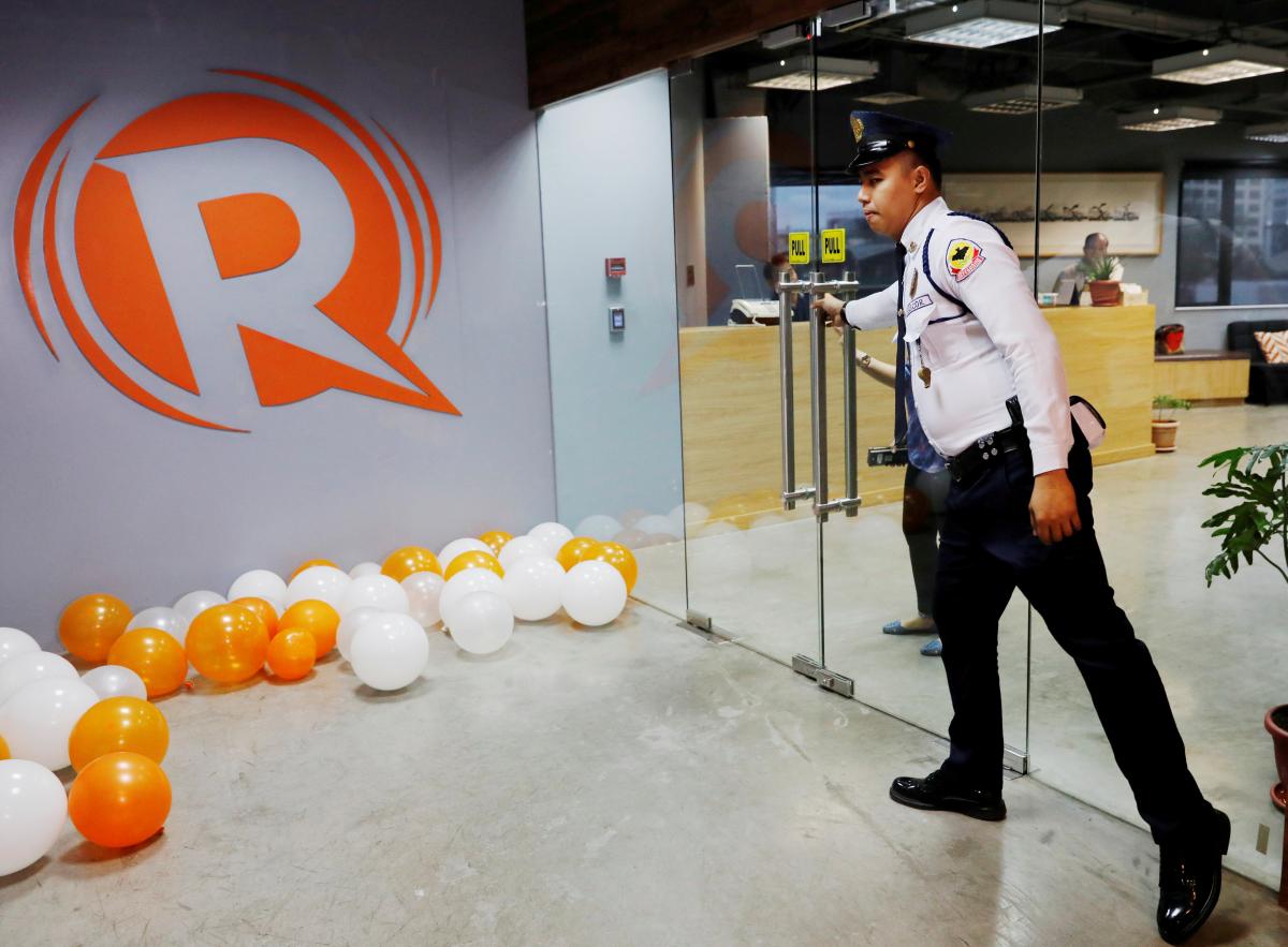 FILE PHOTO: A guard opens a door at the office of Rappler in Pasig