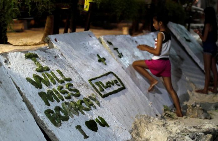 A girl scribbles on a wall two days before the temporary closure of the holiday island Boracay, in the Philippines