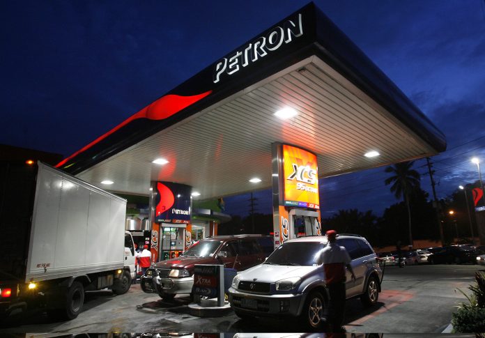 Vehicles are filled with gasoline at a Petron station in Manila