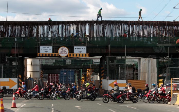 Labourers work at a construction site of a new expressway in Manila