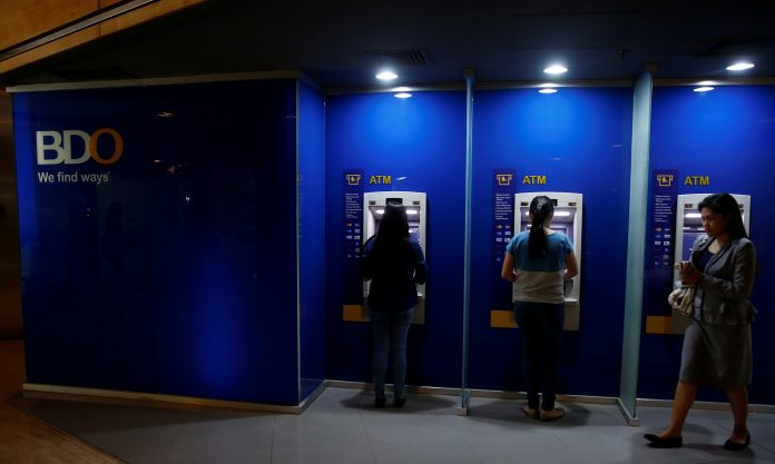 Employees withdraw money from BDO atm machines in financial district in Makati City
