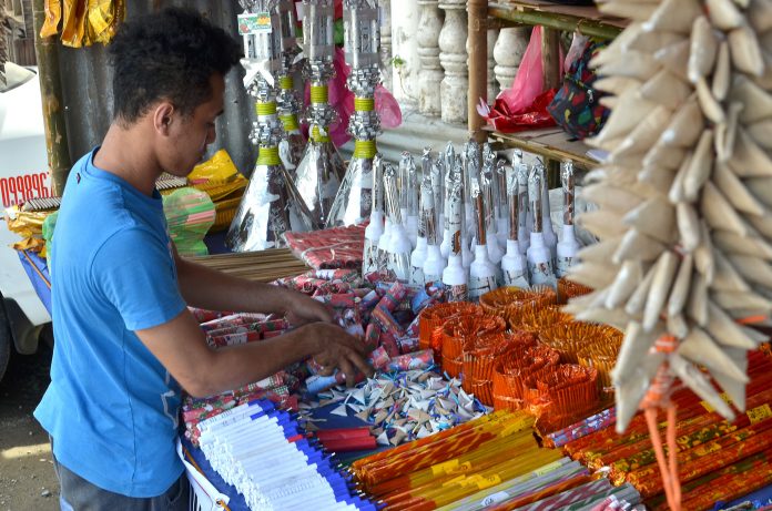 A firecracker vendor in Tigbauan, Iloilo attends to his goods on Dec. 26. Firecrackers can only be sold in designated zones set by the local government unit in coordination with the Philippine National Police and the Bureau of Fire Protection. PN