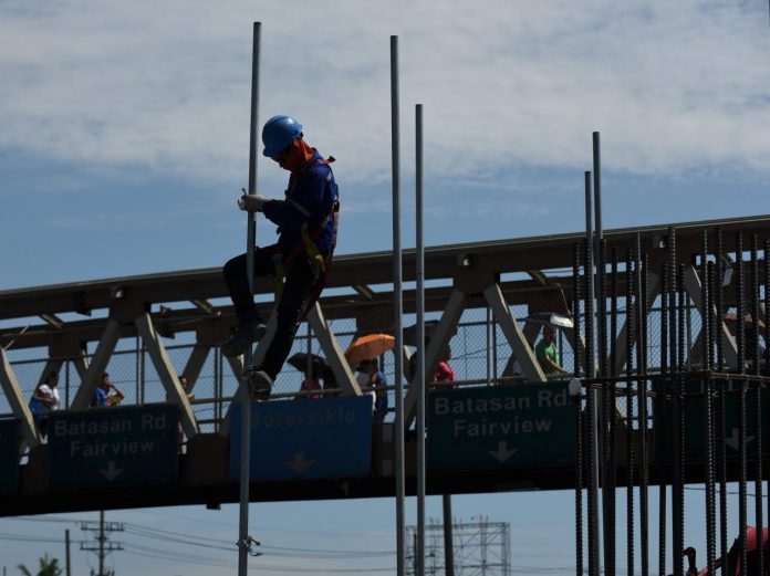 A worker assembles a pole at a construction site of the Metro Rail Transit (MRT)