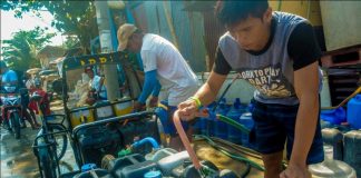 Photo for representation only. A young man fills with water a buyer’s plastic containers in Barangay Mansaya, Lapuz, Iloilo City.