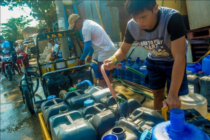 Photo for representation only. A young man fills with water a buyer’s plastic containers in Barangay Mansaya, Lapuz, Iloilo City.