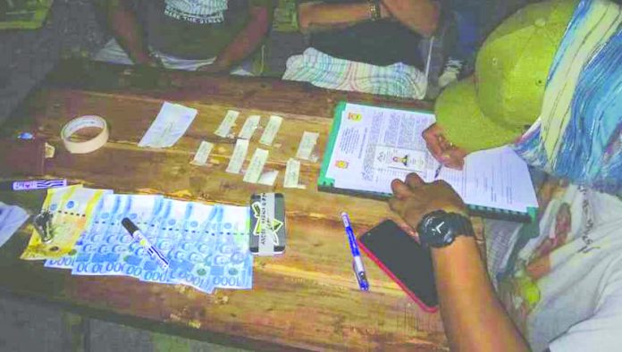 Andre Mabasa Shabu An antidrug personnel examines the suspected shabu and drug paraphernalia seized from Andre Mabasa after he sold illegal drugs to a poseur-buyer in Kalibo, Aklan on June 27. PDEA REGION 6