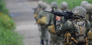 A Philippine Marine officer aims his rifle as he and other Marines head to militant positions in Marawi City on May 30, 2017, three days after martial law was declared in Mindanao. AFP