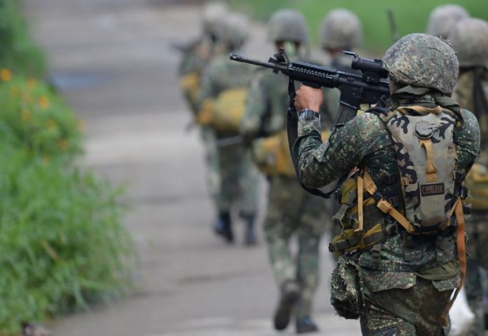 Philippine Marine officer Army A Philippine Marine officer aims his rifle as he and other Marines head to militant positions in Marawi City on May 30, 2017, three days after martial law was declared in Mindanao. AFP