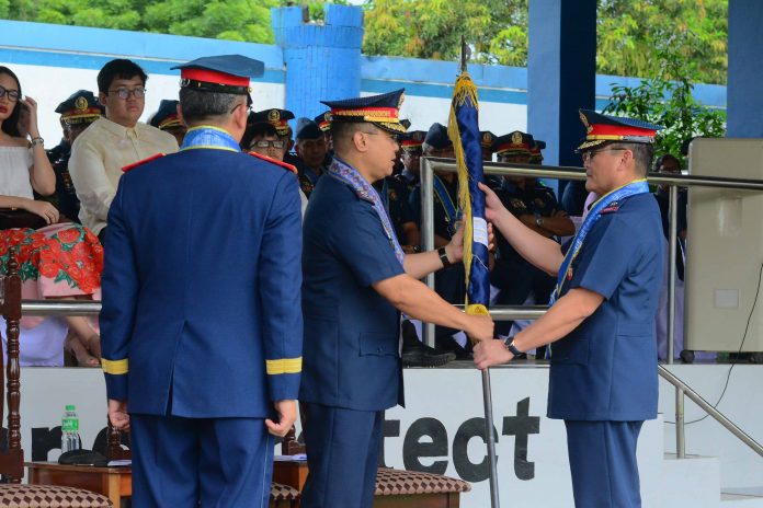 TURNOVER OF COMMAND. Police Brigadier General John Bulalacao (center), outgoing police director of Western Visayas, turns over to his successor, Police Brigadier General Rene Pamuspusan, the Regional Director’s Personal Flag during yesterday afternoon’s (June 27, 2019) turnover ceremony in Camp Delgado, Iloilo City. Looking on is the Philippine National Police’s deputy chief for operations, Police Lieutenant General Archie Francisco Gamboa. IAN PAUL CORDERO/PN