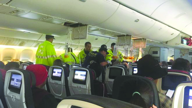 Emergency workers assist passengers on Air Canada flight AC33 after it was diverted to Hawaii. REUTERS