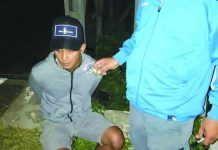 Drug suspect Christopher Benignos of Barangay Dumlog, Malay, Aklan sits handcuffed after police officers caught in an entrapment operation. Benignos allegedly sold a sachet of marijuana to a poseur-buyer on July 13. PDEA REGION 6