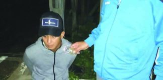 Drug suspect Christopher Benignos of Barangay Dumlog, Malay, Aklan sits handcuffed after police officers caught in an entrapment operation. Benignos allegedly sold a sachet of marijuana to a poseur-buyer on July 13. PDEA REGION 6