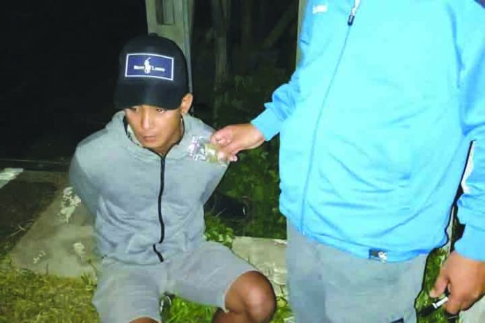 Aklan Marijuana Drug suspect Christopher Benignos of Barangay Dumlog, Malay, Aklan sits handcuffed after police officers caught in an entrapment operation. Benignos allegedly sold a sachet of marijuana to a poseur-buyer on July 13. PDEA REGION 6