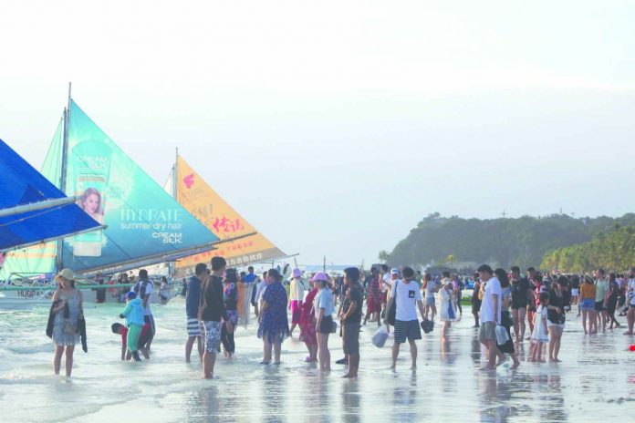 Crowd of tourists enjoy the world-famous white sand beach of Boracay Island in Malay, Aklan. The Boracay Inter-Agency Rehabilitation Management Group last week started the demolition of establishments violating the island’s easement rules. BOY RYAN ZABAL/AKEANFORUM
