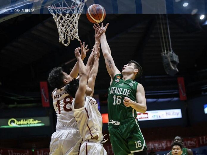Edward Dixon Ilonggo Edward Dixon of the College of St. Benilde Blazers drops a floater against two University of Perpetual Help Altas defenders. ABS CBN SPORTS PHOTO