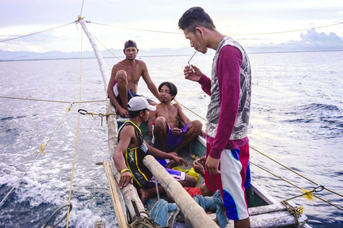 Fisherman A fisherman lights his cigarette as his boat’s crew heads out from a coastal town in Kalibo. THE NEW YORK TIMES
