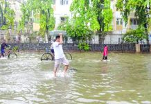 India dam burst kills six An Indian man carries a suitcase on his head as walks along a waterlogged street in Mumbai on Jul 2, 2019, following heavy monsoon rains. Mumbai was lashed by heavy rains for a second consecutive day, bringing the city to a virtual standstill. AFP