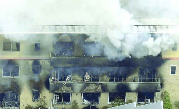 Kyoto animation studio Firefighters work as smoke billows from a three-story building of Kyoto Animation in a fire in Kyoto, western Japan, Thursday, July 18, 2019. Kyoto prefectural police said the fire broke out Thursday morning after a man burst into it and spread unidentified liquid and put fire. Kyodo News via AP