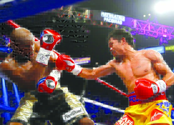 Manny Pacquiao throws a right at Floyd Mayweather Jr. during their welterweight unification championship bout on May 2, 2015 at the MGM Grand Garden Arena in Las Vegas, Nevada. Mayweather won.