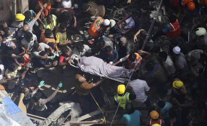 Mumbai Building collapse Rescuers carry the body of a victim at the site of a building that collapsed in Mumbai, India, Tuesday, July 16, 2019. A four-story residential building collapsed Tuesday in a crowded neighborhood in Mumbai, India's financial and entertainment capital, and several people were feared trapped in the rubble, an official said. AP