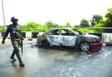 Nigeria parliament on lockdown after clash A policeman walks past a car burnt by supporters of an imprisoned leader of the Islamic Movement of Nigeria Ibrahim Zakzaky around the national assembly building in Nigeria's capital Abuja, on July 9. KOLA SULAIMON/AFP/GETTY IMAGES