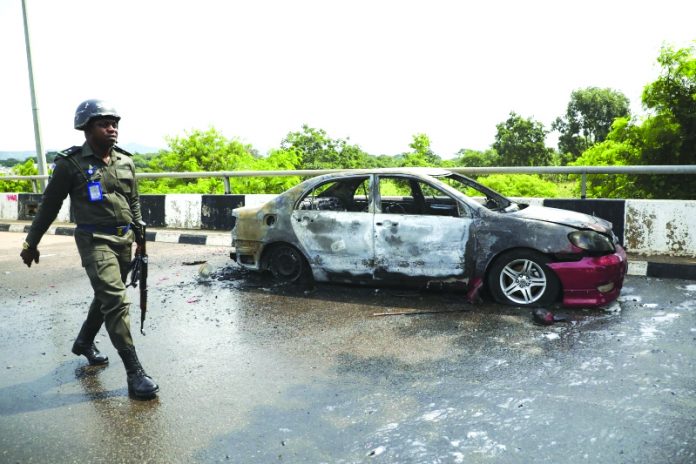 Nigeria parliament on lockdown after clash A policeman walks past a car burnt by supporters of an imprisoned leader of the Islamic Movement of Nigeria Ibrahim Zakzaky around the national assembly building in Nigeria's capital Abuja, on July 9. KOLA SULAIMON/AFP/GETTY IMAGES