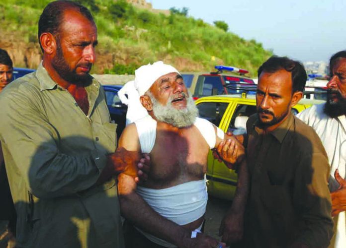 Pakistan army plane crash People help an injured victim who morns for the loss of his family member at the site of plane crash in Rawalpindi, Pakistan, Tuesday, July 30, 2019. AP