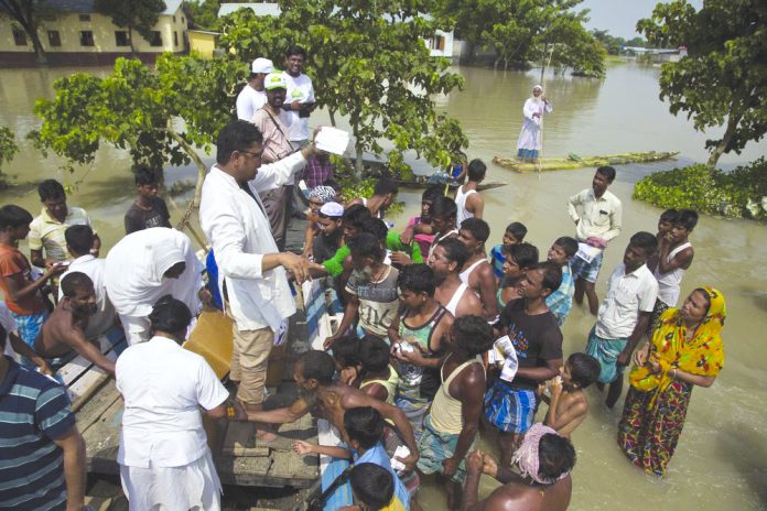 Medical officers distribute medicines to flood victims in Gagalmari, in the northeastern Indian state of Assam, Friday, July 19, 2019. In the Indian state of Assam, officials said floodwaters have killed more than a dozen people and brought misery to some 4.5 million. AP