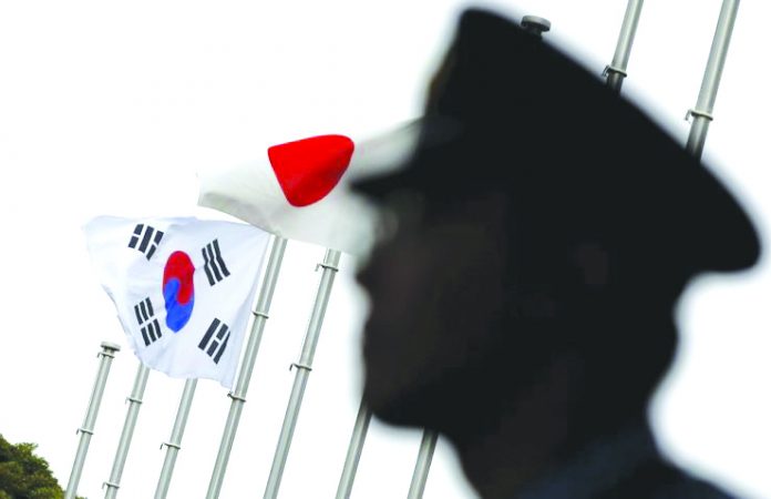 South Korean national flags A police officer stands guard near Japanese and South Korean national flags at a hotel, where the South Korean embassy in Japan is holding a reception to mark the 50th anniversary of the normalization of ties between Seoul and Tokyo, in Tokyo, June 22, 2015. REUTERS
