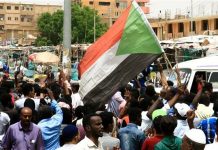 Sudan security forces raid opposition office Sudanese people chant slogans and wave Sudanese flags during a demonstration in Khartoum, Sudan. REUTERS