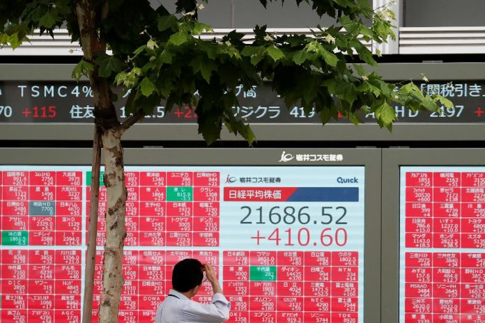 Tokyo, Japan A man looks at a stock quotation board outside a brokerage in Tokyo, Japan. REUTERS