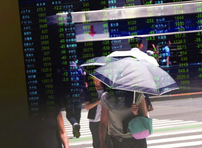 Passersby are reflected on a stock quotation board outside a brokerage in Tokyo, Japan on August 6, 2019. Asian shares fell on yesterday morning, while gold prices held firm as investors worried over a prolonged Sino-US trade war. REUTERS