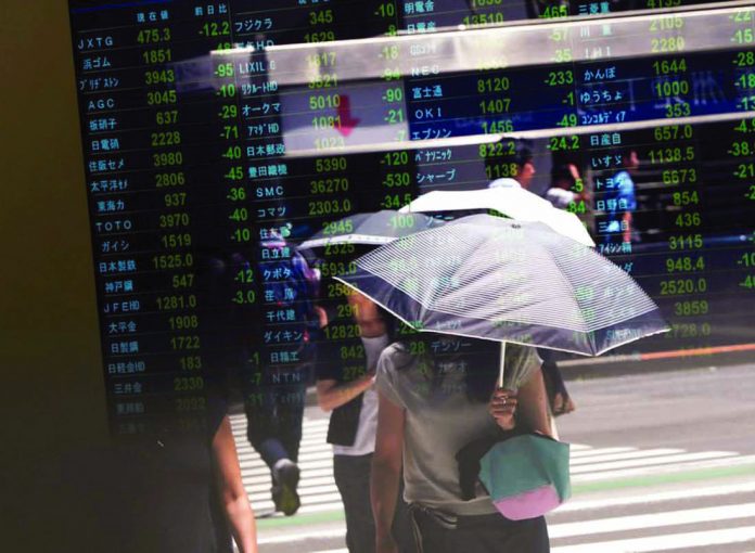 Asian shares Passersby are reflected on a stock quotation board outside a brokerage in Tokyo, Japan on August 6, 2019. Asian shares fell on yesterday morning, while gold prices held firm as investors worried over a prolonged Sino-US trade war. REUTERS