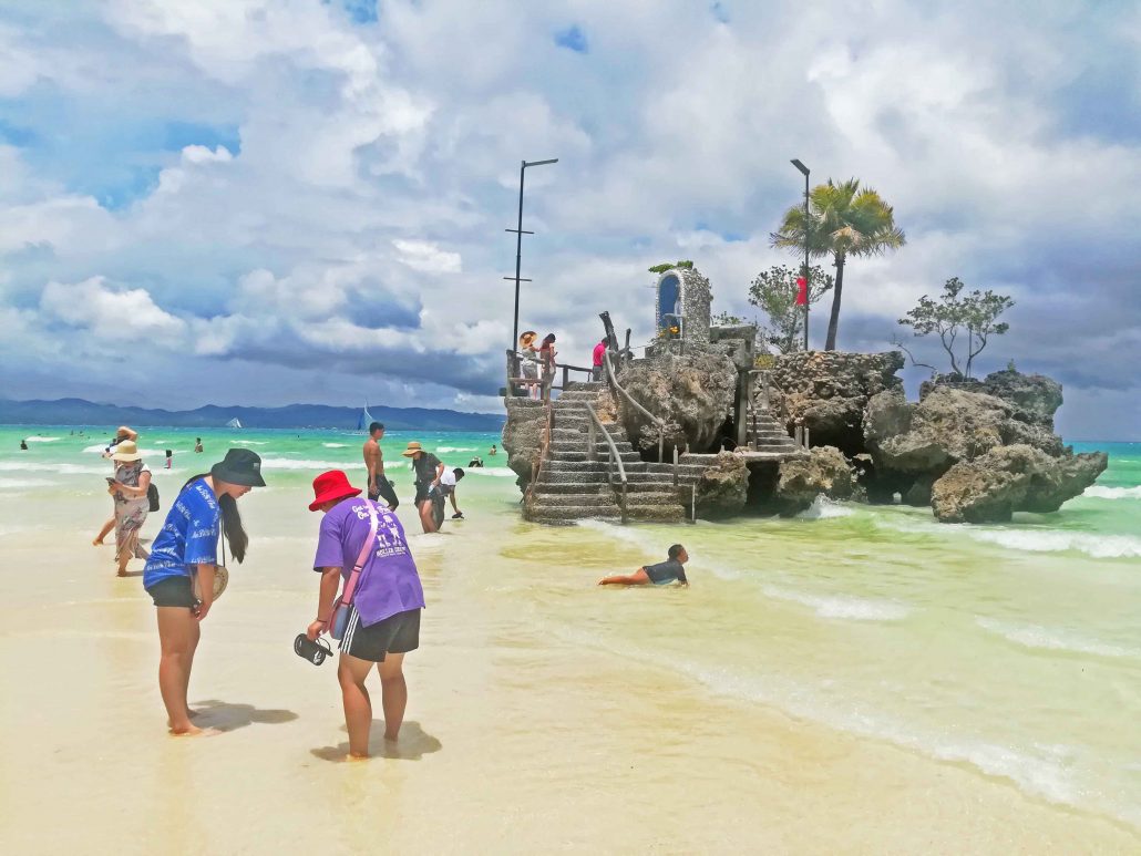 Tourists wade to the floating grotto along Station 1.
