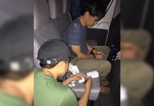 Drug suspect Carlo Boncalon (left) sits handcuffed after police officers arrested him in an entrapment operation in Barangay 10, Bacolod City on Aug. 26. PDEA REGION VI – WESTERN VISAYAS