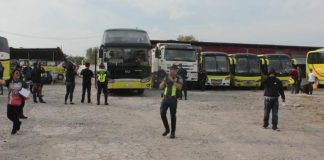 Policemen secure Ceres buses at the Dynamic Builders compound in Barangay Alijis, Bacolod City. ARCHIE REY ALIPALO/PN