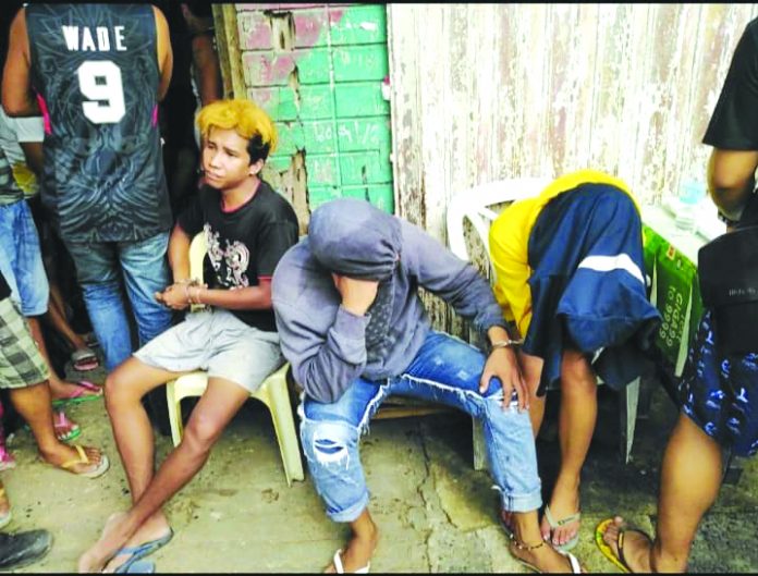 Drug suspects (from left) Cristel Ann Alcazaren, John Mark Distor and Jet Jet Alberto are handcuffed after police officers caught them in an entrapment operation in Barangay VIII, Roxas City on July 31. GLENN BEUP/PN