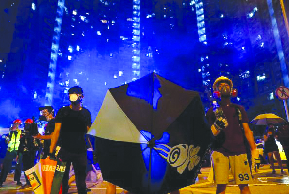 Hong Kong protest tear gas A man reacts in tear gas as riot police try to disperse them at Wong Tai Sin, a residential area, after an anti-extradition bill protest in Hong Kong, China August 4, 2019. REUTERS