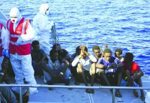 Migrants are evacuated by Italian Coast guards from the Open Arms Spanish humanitarian boat at the coasts of the Sicilian island of Lampedusa, southern Italy, Saturday, Aug. 17, 2019. AP