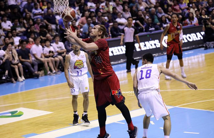 San Miguel Beermen’s June Mar Fajardo evades the defense of TNT KaTropa’s Jeth Troy Rosario for an easy inside basket in Game 4 of the 2019 Honda PBA Commissioner’s Cup finals on Sunday. PBA PHOTO
