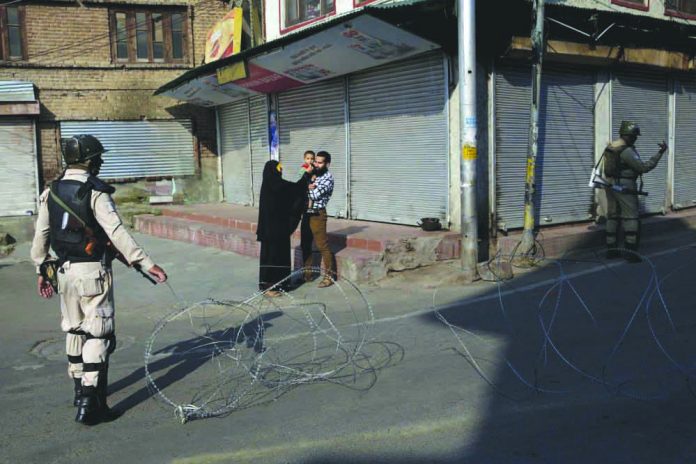 Kashmiri A Kashmiri family waits for a lift to take their sick child to hospital as Indian paramilitary soldiers stand guard near a checkpoint during lockdown in Srinagar, India on Aug. 23, 2019. AP