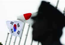 South Korea warns Japan of security pact risk A police officer stands guard near Japan and South Korea national flags at a hotel, where the South Korean embassy in Japan is holding the reception to mark the 50th anniversary of the normalisation of ties between Seoul and Tokyo, in Tokyo June 22, 2015. REUTERS