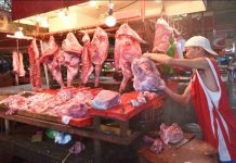 STILL SAFE. A vendor at the Iloilo Terminal Market inspects the meat and pork he is selling. They are safe, he insists. The deadly African swine fever virus has reached the country. IAN PAUL CORDERO/PN