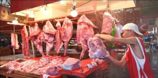 STILL SAFE. A vendor at the Iloilo Terminal Market inspects the meat and pork he is selling. They are safe, he insists. The deadly African swine fever virus has reached the country. IAN PAUL CORDERO/PN