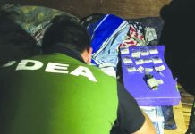 An antidrug operative inspects sachets of suspected shabu seized in Purok Sibucao, Barangay Banago, Bacolod City on Aug. 3. PDEA REGION 6