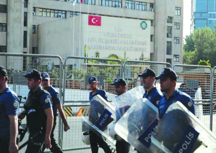 Turkish police Turkish police walk in front of the Metropolitan Municipality headquarters in Diyarbakir, Turkey, Aug. 19, 2019. REUTERS