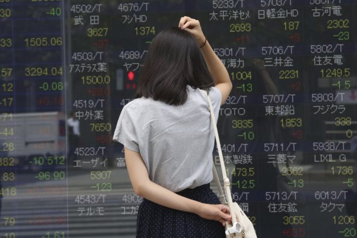Asian stocks A woman looks at an electronic stock board of a securities firm in Tokyo, Monday, Sept. 2, 2019. Asian stocks are mixed yesterday after Washington and Beijing escalated their trade war with new tariff hikes. AP/KOJI SASAHARA