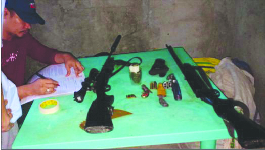 An officer of the police station in Barotac Viejo, Iloilo checks firearms confiscated from Cristobal Debil. BAROTAC VIEJO MPS