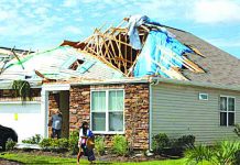 A girl removes personal belongings from her damaged home after a tornado spawned by Hurricane Dorian ripped apart her roof in Carolina Shores, North Carolina, U.S. on Sept. 6, 2019. REUTERS