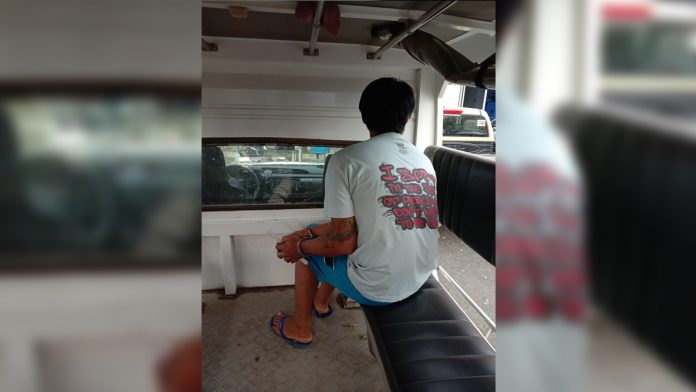 Frustrated murder and rape suspect Jacklin Elauria sits handcuffed after police officers arrested him in Barangay Lawaan, Roxas City, Capiz on Thursday. GLENN BEUP